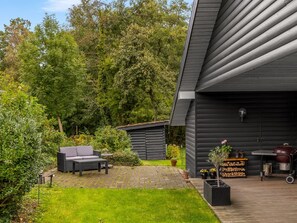 Eine moderne Terrassenanlage im Freien mit integriertem Grill und Sitzgelegenheit.