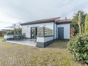 A modern house with a patio, outdoor seating, and a garden. - Holiday Home With 2 Bedrooms (Burgh-Haamstede)