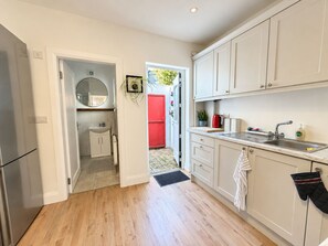 Une cuisine avec des meubles blancs, un évier et une cuisinière.