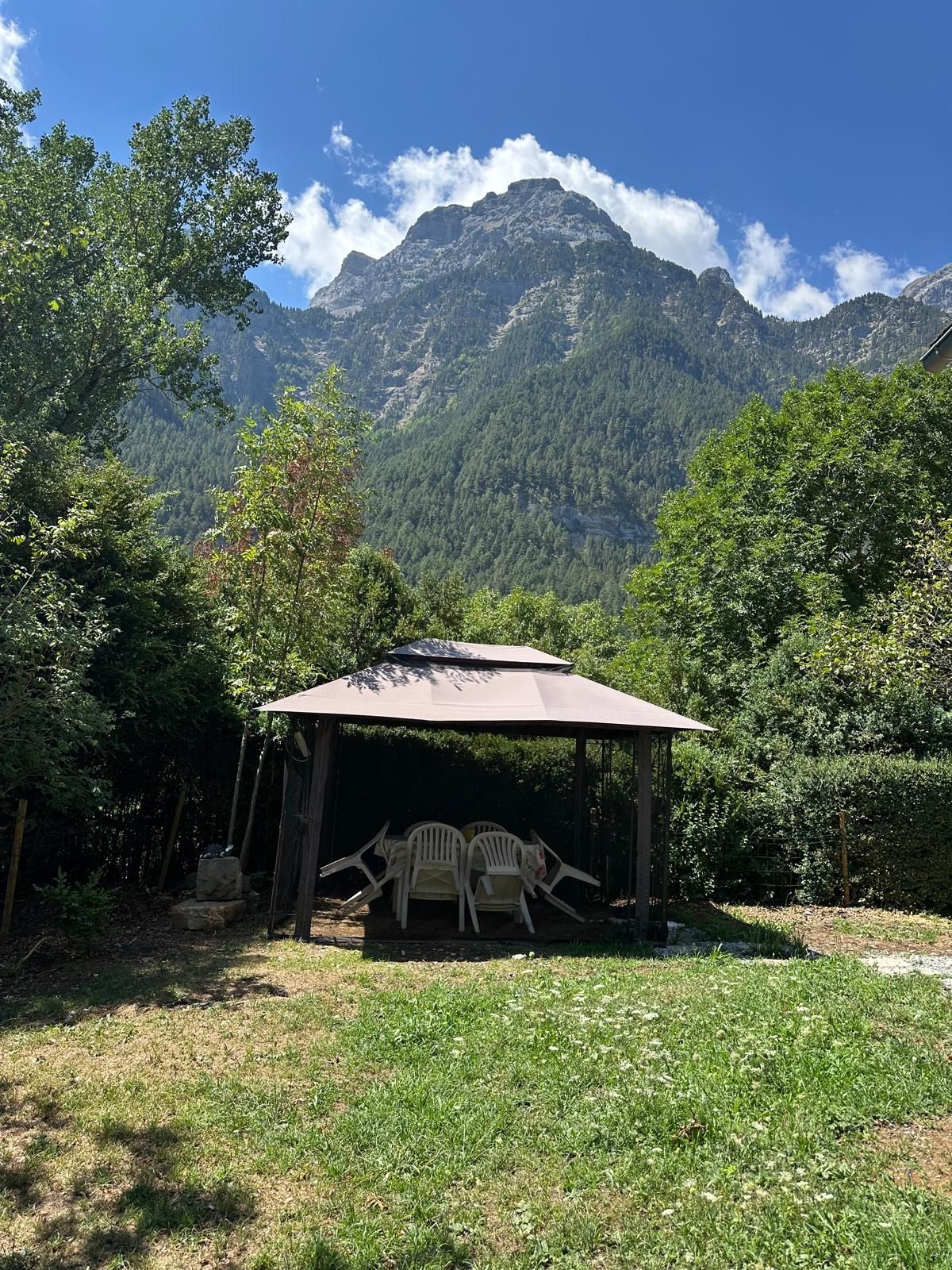 A covered outdoor seating area with a mountain backdrop.