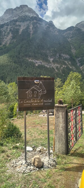 A sign for 'La Casa de la Amistad' with a mountain backdrop.