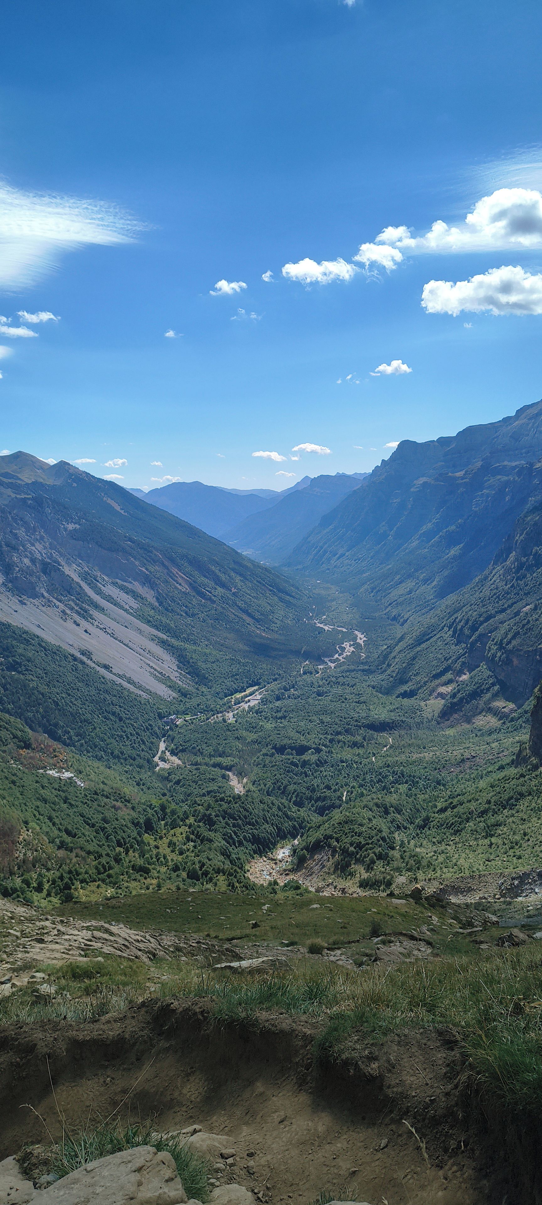 A mountainous landscape with a valley and a river.