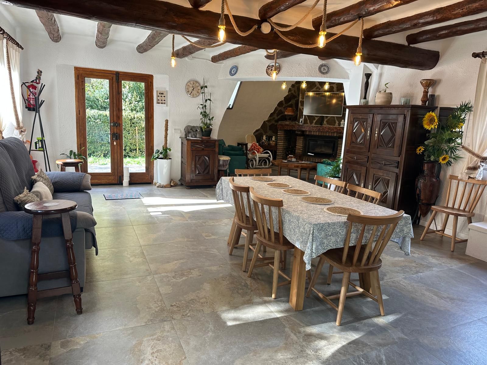 Un comedor rústico con una larga mesa de madera, sillas y una chimenea.