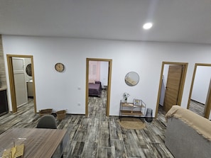 A room with a wooden floor, a bed, a small table with a vase, and a mirror on the wall. - Holiday Home 'Casa Chocolate 2.0' with Private Pool, Private Garden and Air Conditioning (Pago del Humo)