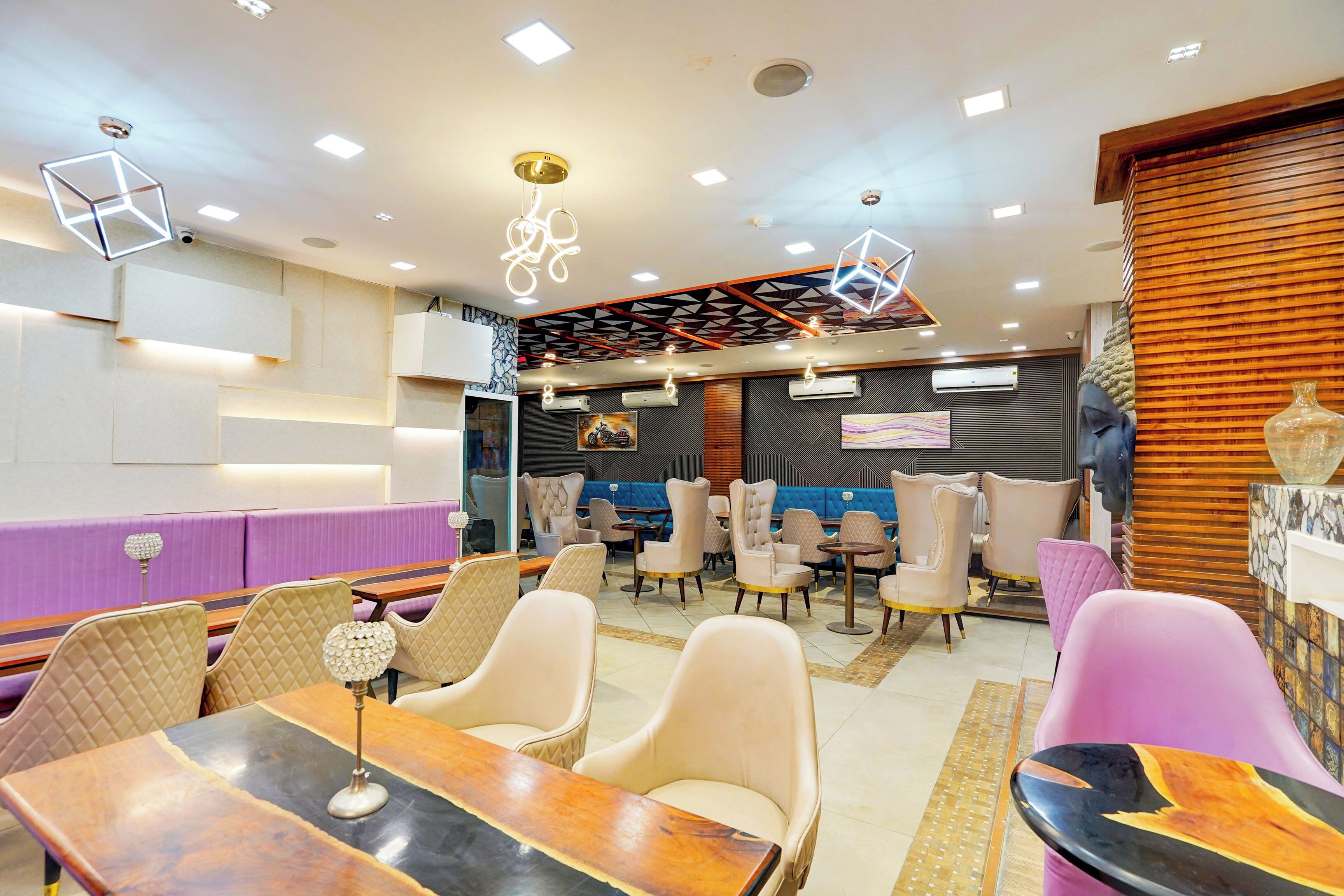 A restaurant with multiple seating areas, including booths and tables, and a variety of ceiling designs.