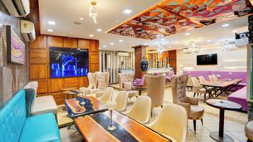 Un interior moderno con zonas de estar, un televisor de pantalla plana grande e iluminación decorativa.