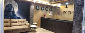 A reception area with a sofa, a counter, and clocks labeled with locations.