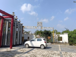 A white car parked in front of a building with a sign that reads 'EMERALD SAFARI'.