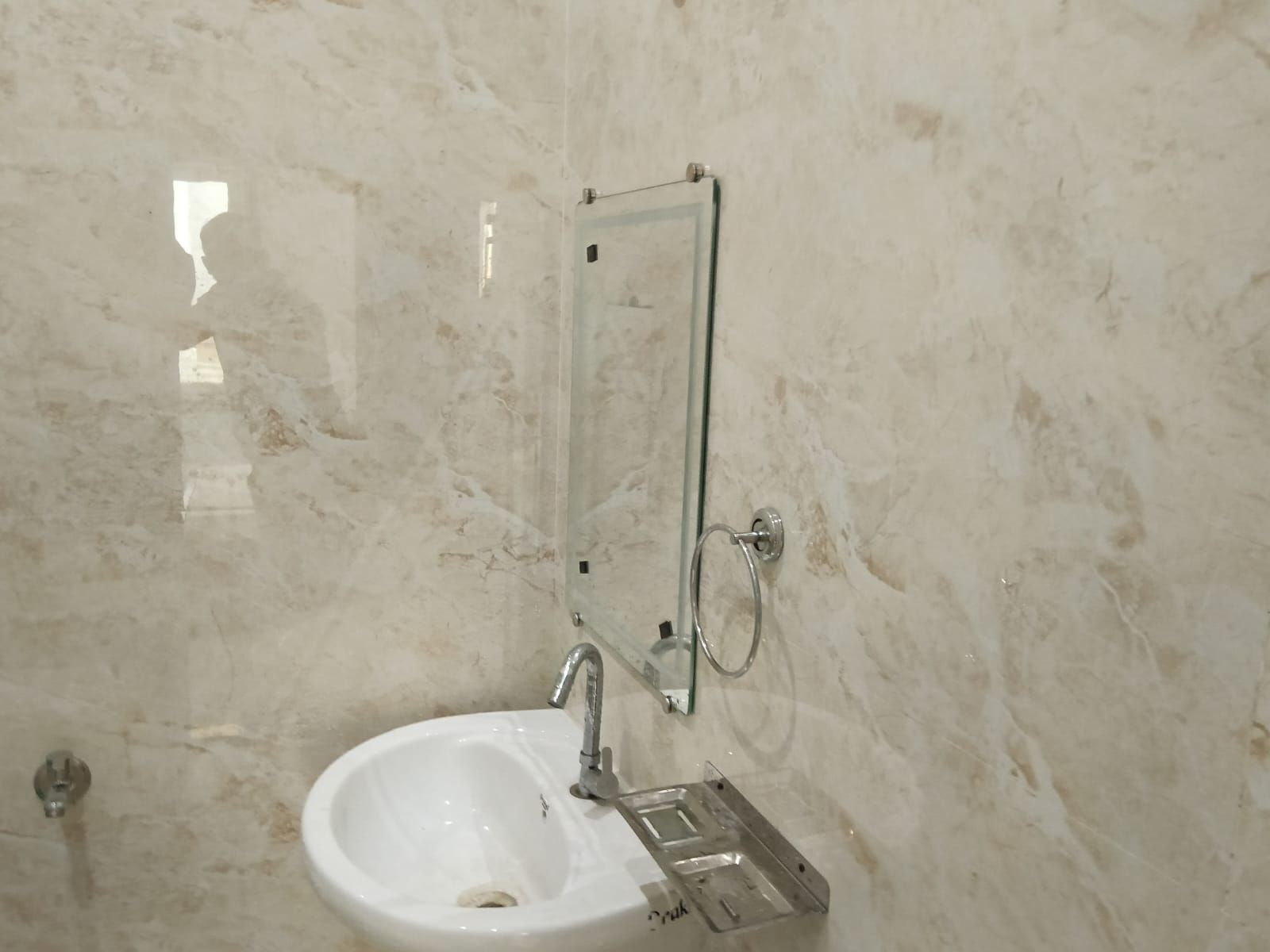 A bathroom with a white sink, a mirror, and a towel rack.