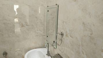 A bathroom with a white sink, a mirror, and a towel rack.