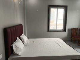 Quarto com cama, janela e cadeira.