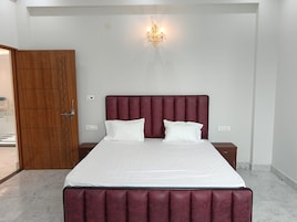 Un dormitorio con una cama grande, un armario de madera y un candelabro.