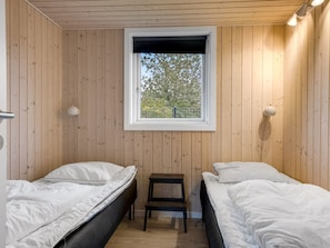 A room with two beds, a window, and a small table. - "Ellanor" - 100m from the sea by Interhome (Broager)