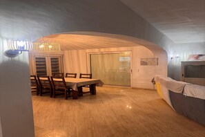 Ein Essbereich mit Tisch und Stühlen, einer Kristallleuchter und einer Schiebetür zu einem anderen Raum.