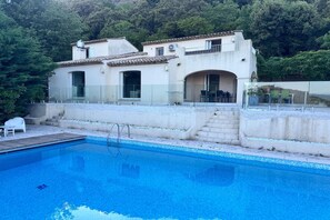 Ein zweistöckiges Gebäude mit einem Pool davor.