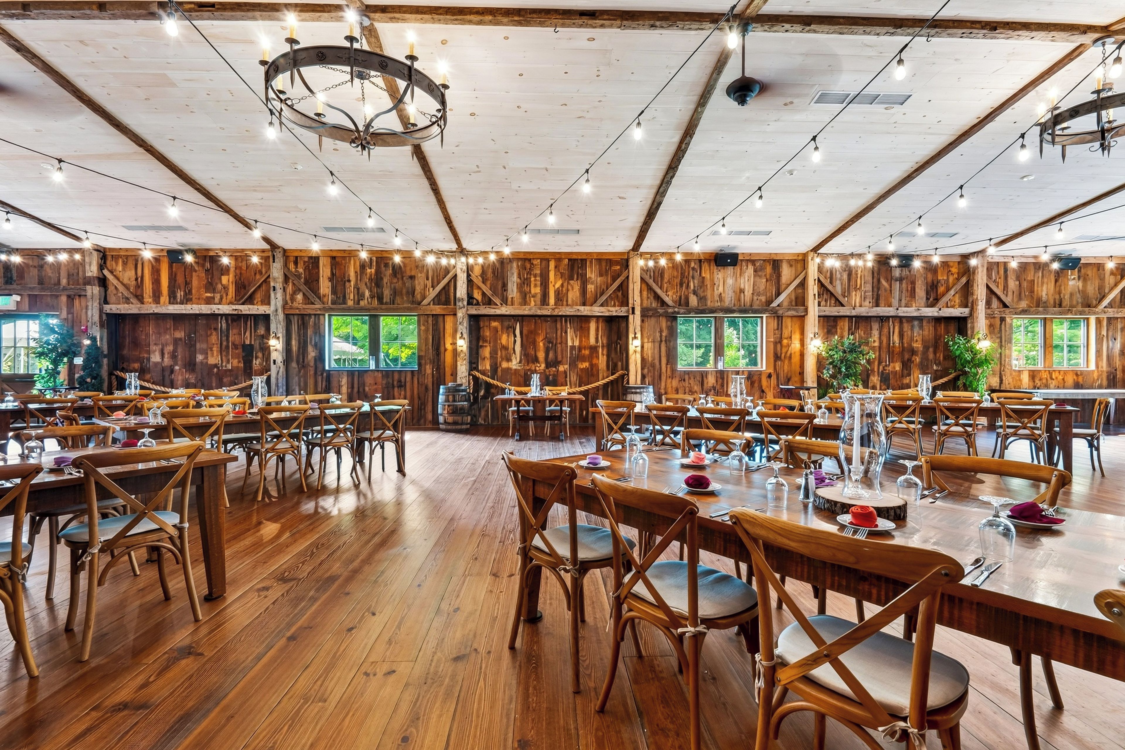 A spacious dining hall with wooden walls and tables set for dining.