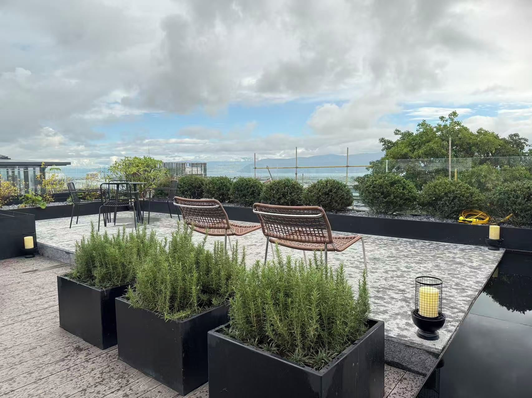 Une terrasse sur le toit, aménagée avec des sièges, des jardinières et offrant une vue sur la mer.