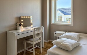 A bedroom with a vanity, a chair, a bed, a nightstand, and a window with a view of a house. - Lovely home in Gnarp with house a panoramic view (Gnarp)