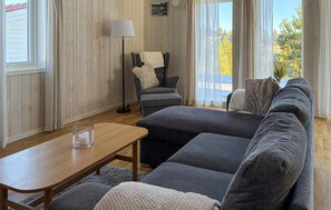 A cozy living room with a sofa, a coffee table, and a floor lamp. - Lovely home in Gnarp with house a panoramic view (Gnarp)