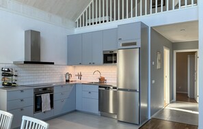 A modern kitchen with grey cabinets, stainless steel appliances, and a white tiled backsplash. - Lovely home in Gnarp with house a panoramic view (Gnarp)