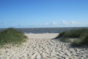 A sandy beach with a clear sky and ocean in the background. - Holiday home in Minsen with swimming pool (Minsen)