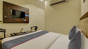 Une chambre d’hôtel équipée d’un lit, d’un téléviseur fixé au mur et d’un appareil de climatisation.