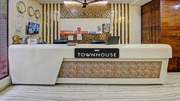 A reception desk with a sign reading 'TOWNHOUSE' and a ceiling fan above.