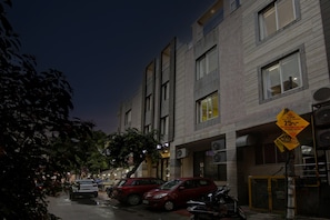 A multi-story building with commercial spaces on the ground floor, including a salon and a school. - Townhouse Grand Inn (Ghaziabad)