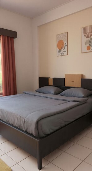 Un dormitorio con cama, cabecera y dos armarios empotrados.