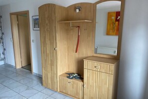 A room with a wardrobe, a mirror, and a radiator. - Living at the Moor 2 (Ihlow-Westersander)