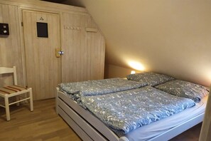 Ein Schlafzimmer mit einem Bett, einem Sessel und einem Holzschrank.