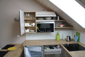 Eine kleine Küche mit eingebautem Backofen, einer Mikrowelle und einer Arbeitsfläche.