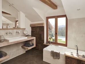 A modern bathroom with a large window, a bathtub, and a vanity with a mirror. - Holiday Home With 2 Bedrooms (Wonneberg)