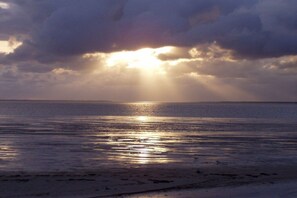 A beach with sunlight reflecting on the water. - Holiday apartment with 2 bedrooms (Werdum)