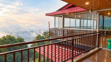 Un balcón con barandilla de madera que da a un paisaje montañoso.