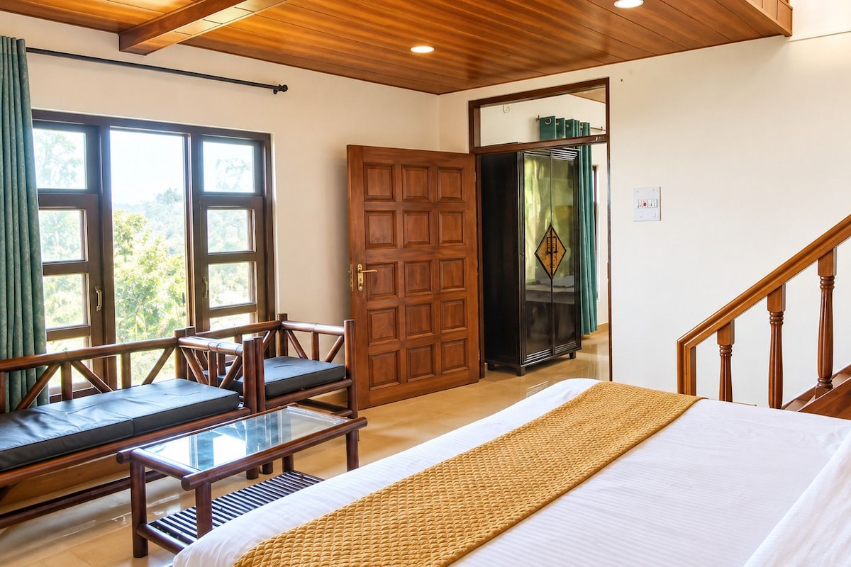 A bedroom with a bed, a wooden bench, a desk, and a staircase.