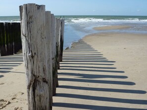 A wooden pier extending into the ocean with a sandy beach and waves in the background. - Do04 Holiday Home Domburg (Domburg)