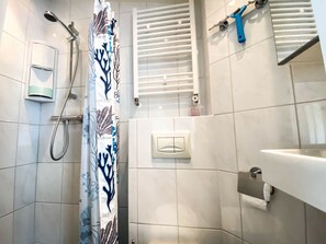 A bathroom with a shower, a toilet, a sink, and a towel rack. - Do04 Holiday Home Domburg (Domburg)