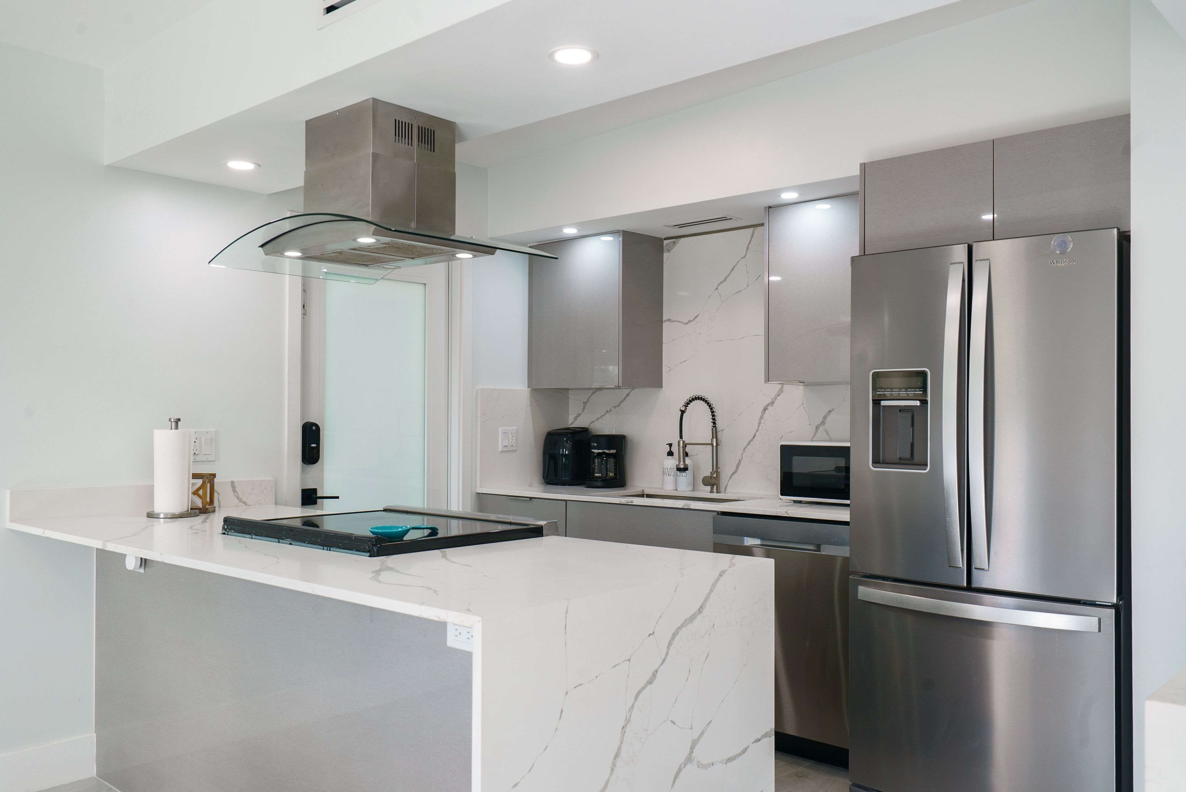 A modern kitchen with a central island, stainless steel appliances, and a sleek design.