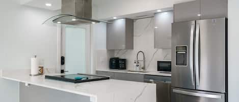 A modern kitchen with a central island, stainless steel appliances, and a sleek design.