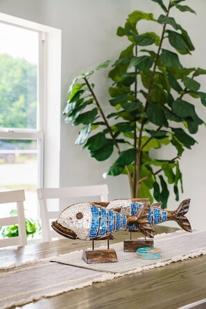 A mosaic fish decoration on a wooden table with a plant in the background. - Relaxation Time: Fenced yard, Screened Porch, Close to the Beach (Key Largo)