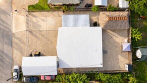An aerial view of a parking lot with several vehicles, a large white tent, and a green tent. - Relaxation Time: Fenced yard, Screened Porch, Close to the Beach (Key Largo)