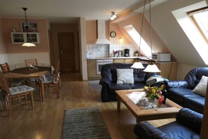 Ein gemütliches Wohnzimmer mit Esstisch, Ledersofas und einem Couchtisch.