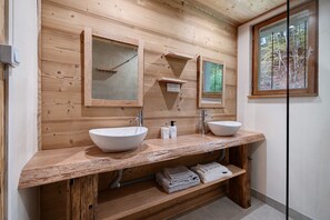 A wooden cabin bathroom with two sinks, a mirror, and a window. - Apartment 'Appartement de montagne' (Queige)