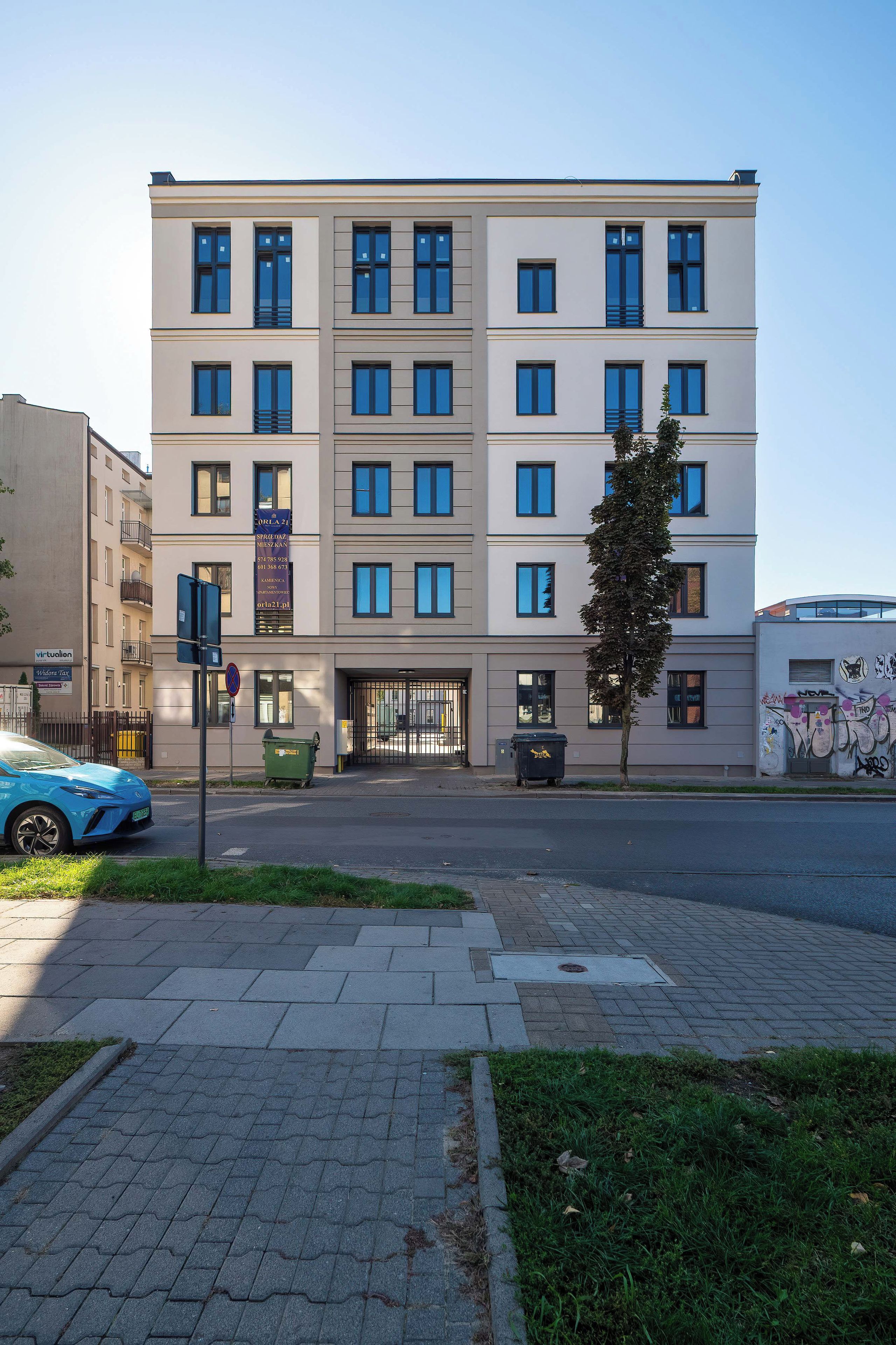 A multi-story building with a flat facade, large windows, and a gated entrance.
