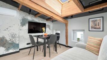 Ein moderner Wohnbereich mit Essplatz, einer Couch und einem Fernseher.