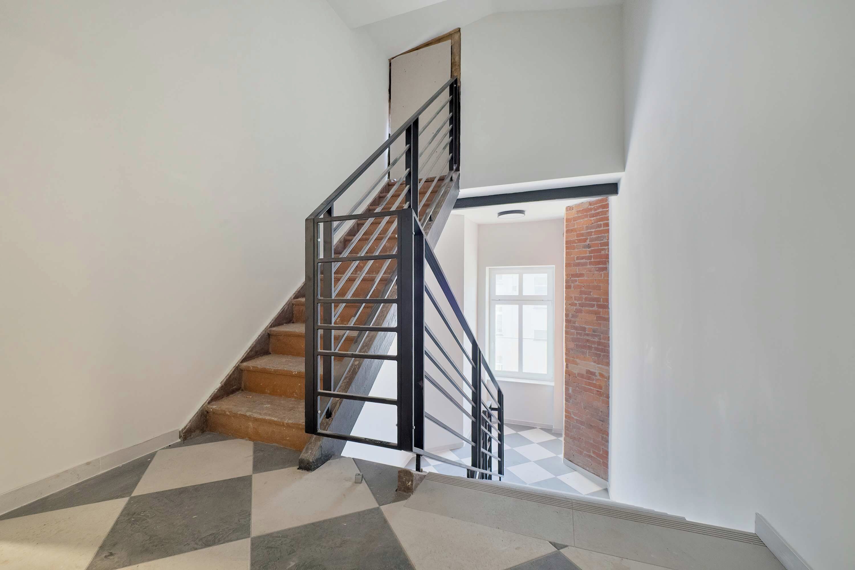 A staircase with a metal railing leading to a landing.