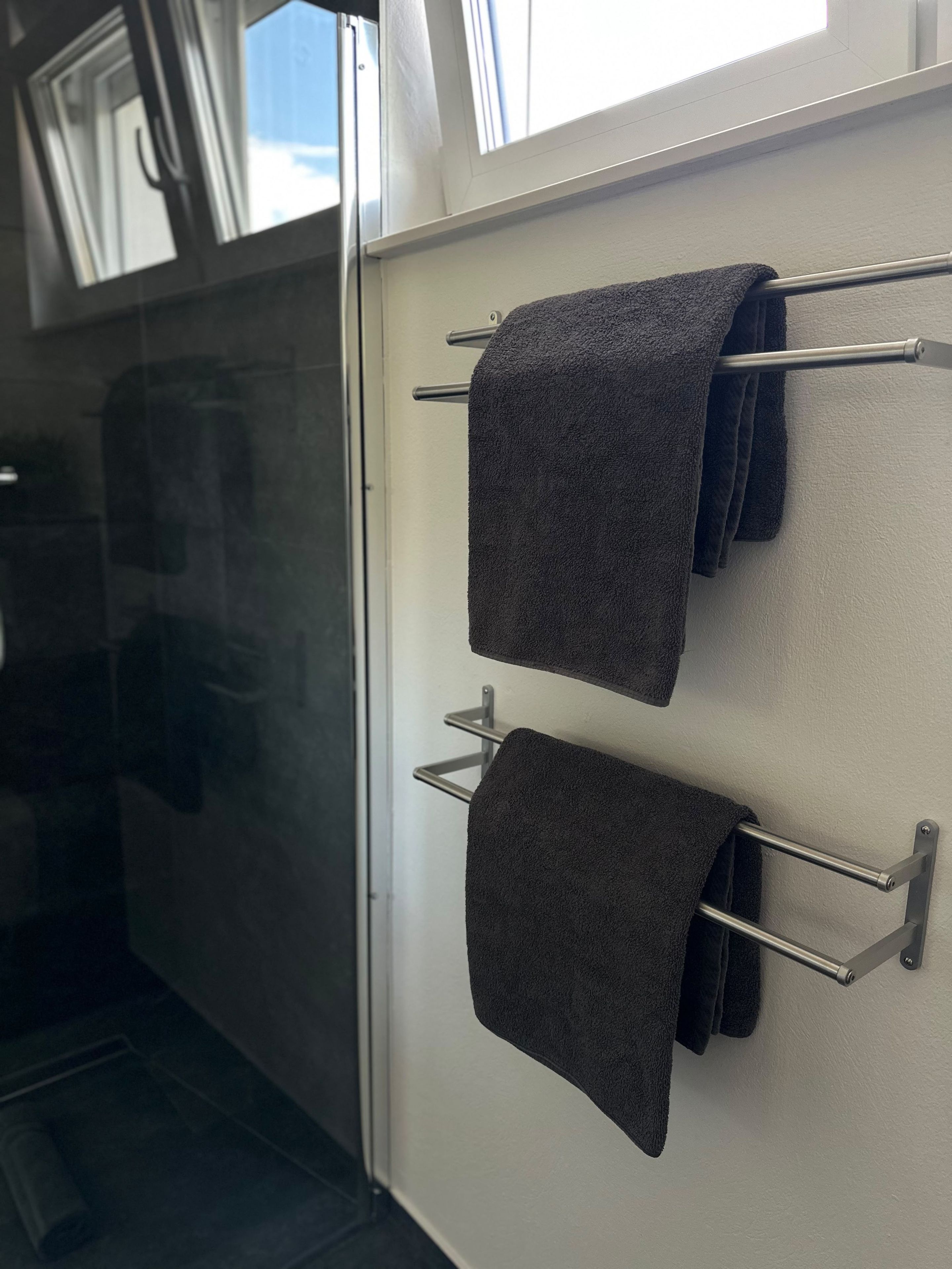 Ein Badezimmer mit einem Handtuchhalter, der zwei Handtücher trägt.