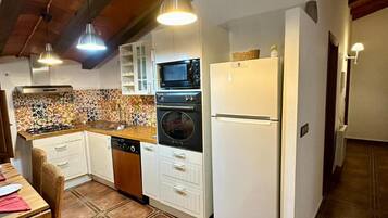 Una cocina con estufa, horno, microondas y refrigerador.