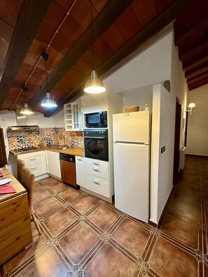 Una cocina con estufa, horno, microondas y refrigerador.